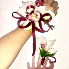 White orchid corsage and boutonniere with burgundy ribbon