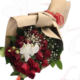 Bouquet of red roses with white orchids wrapped in brown paper