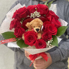Bouquet of red roses with a teddy bear and white lace wrap