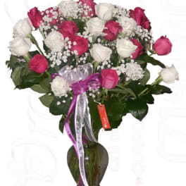 Bouquet of pink and white roses in a glass vase with ribbon