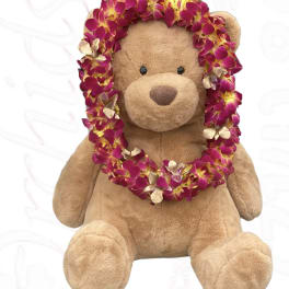 Teddy bear wearing a magenta flower lei