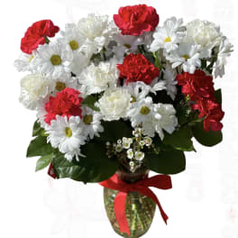 Bouquet of red carnations and white daisies in a glass vase
