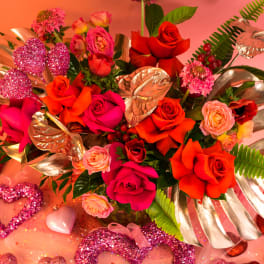 Bright bouquet of roses with metallic leaves and glitter heart decorations