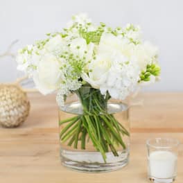 White roses and white blooms in a clear glass vase
