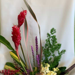 Tropical floral arrangement with red ginger, purple blooms, and red anthuriums