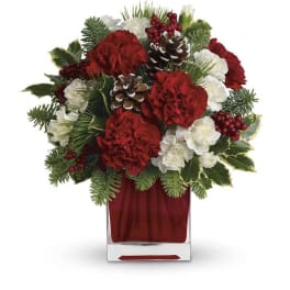 Red and white floral arrangement in a clear square vase