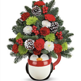 Penguin-shaped container holding a Christmas floral arrangement