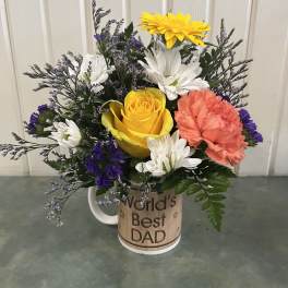 Mixed flower bouquet in a mug reading "World's Best Dad"