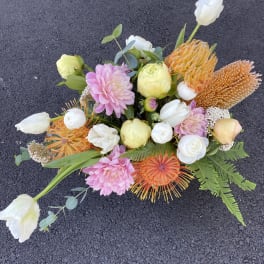 Mixed bouquet with pink, white, and orange flowers on a dark surface