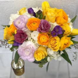 Bouquet of yellow, orange, purple, and white flowers in a vase