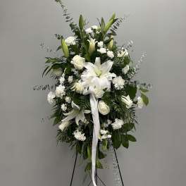 White lilies and roses in a standing spray on an easel