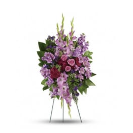 Standing spray of purple and pink flowers on a wire easel
