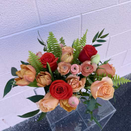 Bouquet of red and peach roses with fern foliage