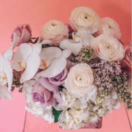 Bouquet of pale pink and white flowers in a clear vase