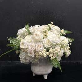 White floral arrangement in a ribbed ceramic vase