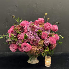 Pink rose and orchid arrangement in a ribbed vase