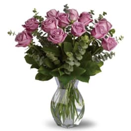 Lavender roses arranged in a clear glass vase