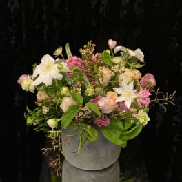 Mixed pink and white floral arrangement in a gray vase
