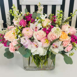 Mixed pink and white floral arrangement in a clear glass vase