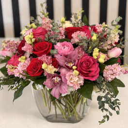 Mixed pink and red flower bouquet in a clear glass vase