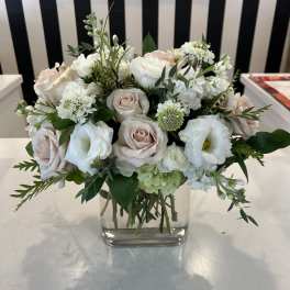 White and blush bouquet in a clear square vase