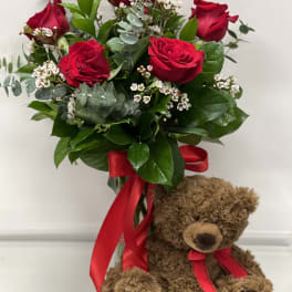 Red rose bouquet with a teddy bear and red ribbon
