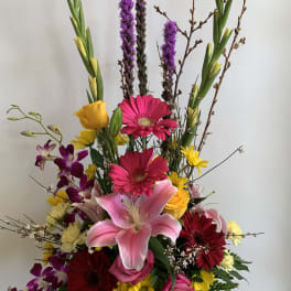 Tall mixed bouquet with lilies, gerbera daisies, roses, and orchids