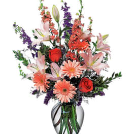 Mixed bouquet of lilies, roses, and daisies in a glass vase