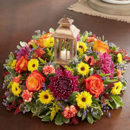 Round floral wreath with a lantern candle centerpiece