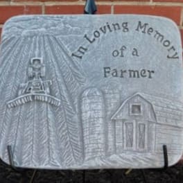 Memorial plaque with a farm scene and the words 'In Loving Memory of a Farmer'