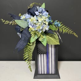 Blue hydrangea arrangement with a thin blue line flag plaque