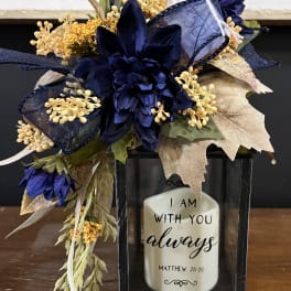 Silk floral arrangement in a black lantern with a memorial candle