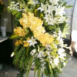 Tall standing floral spray with white lilies and yellow roses