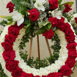 Red and white floral funeral wreath on a wooden easel