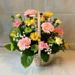 Basket arrangement of pink carnations and yellow daisies
