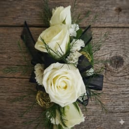 Small arrangement of white roses and carnations with black ribbon on rustic wood