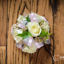Small bouquet of white roses with pink ribbon accents