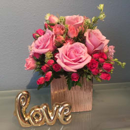 Pink rose bouquet in a rose-gold vase with a gold "love" decoration