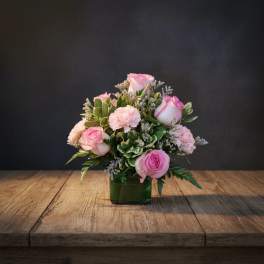 Pink roses and carnations in a green glass vase