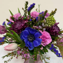 Bouquet of blue, pink, and purple flowers with a pale tulip