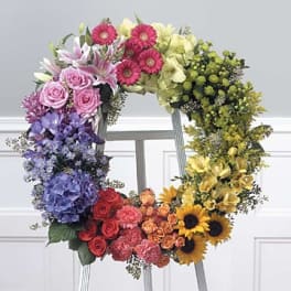 Rainbow floral wreath with mixed blooms on a stand