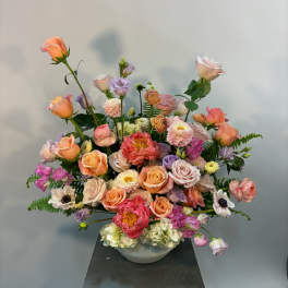 Large pastel floral arrangement in a white bowl vase