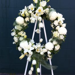 White floral wreath on a standing easel with trailing tulips