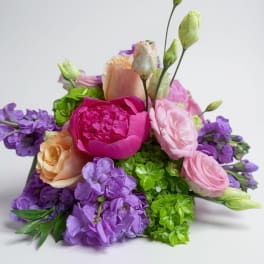Bouquet of pink, purple, and peach flowers with green accents