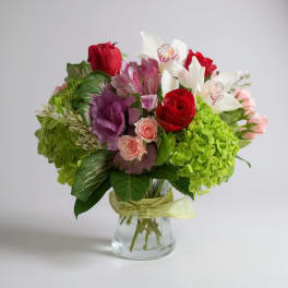 Bouquet of red, white, pink, and green flowers in a glass vase