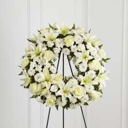 White floral wreath on a black easel stand