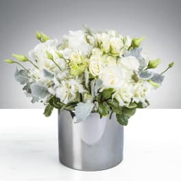 White roses and lisianthus in a silver vase