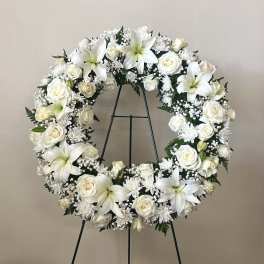 White floral wreath on a black stand