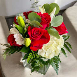 Red roses and white hydrangea in a square glass vase