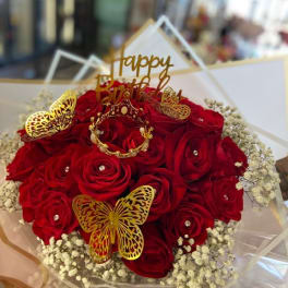 Bouquet of red roses with gold butterfly decorations and a birthday topper
